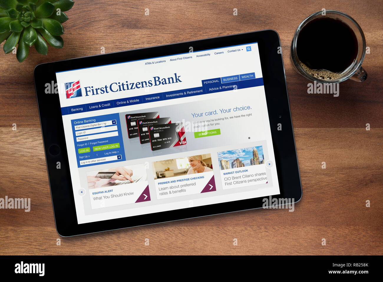 Le site Web de First Citizens Bank est vu sur un iPad tablet, sur une table en bois avec une machine à expresso et d'une plante (usage éditorial uniquement). Banque D'Images