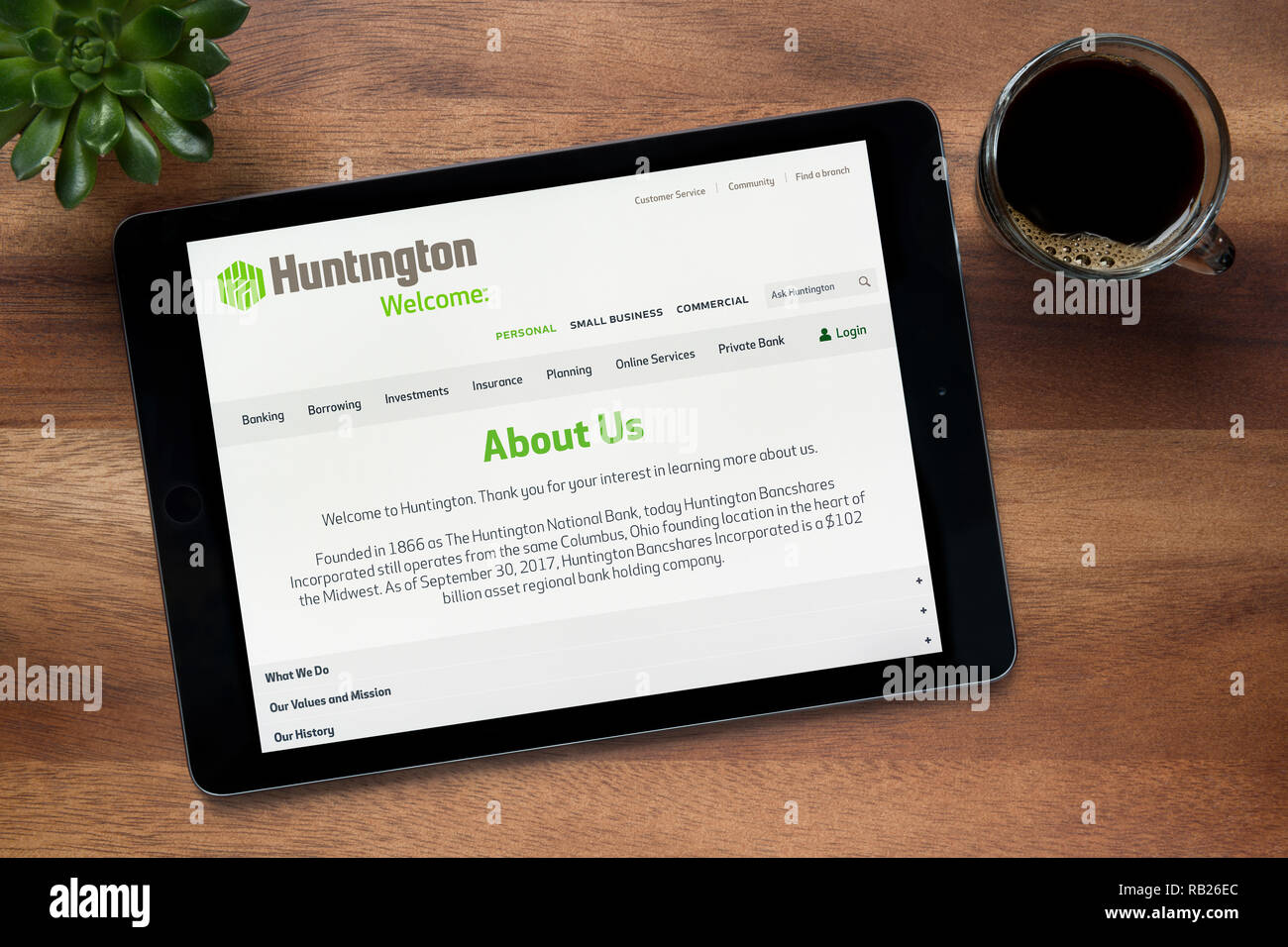 Le site web de banque Huntington est vu sur un iPad tablet, sur une table en bois avec une machine à expresso et d'une plante (usage éditorial uniquement). Banque D'Images