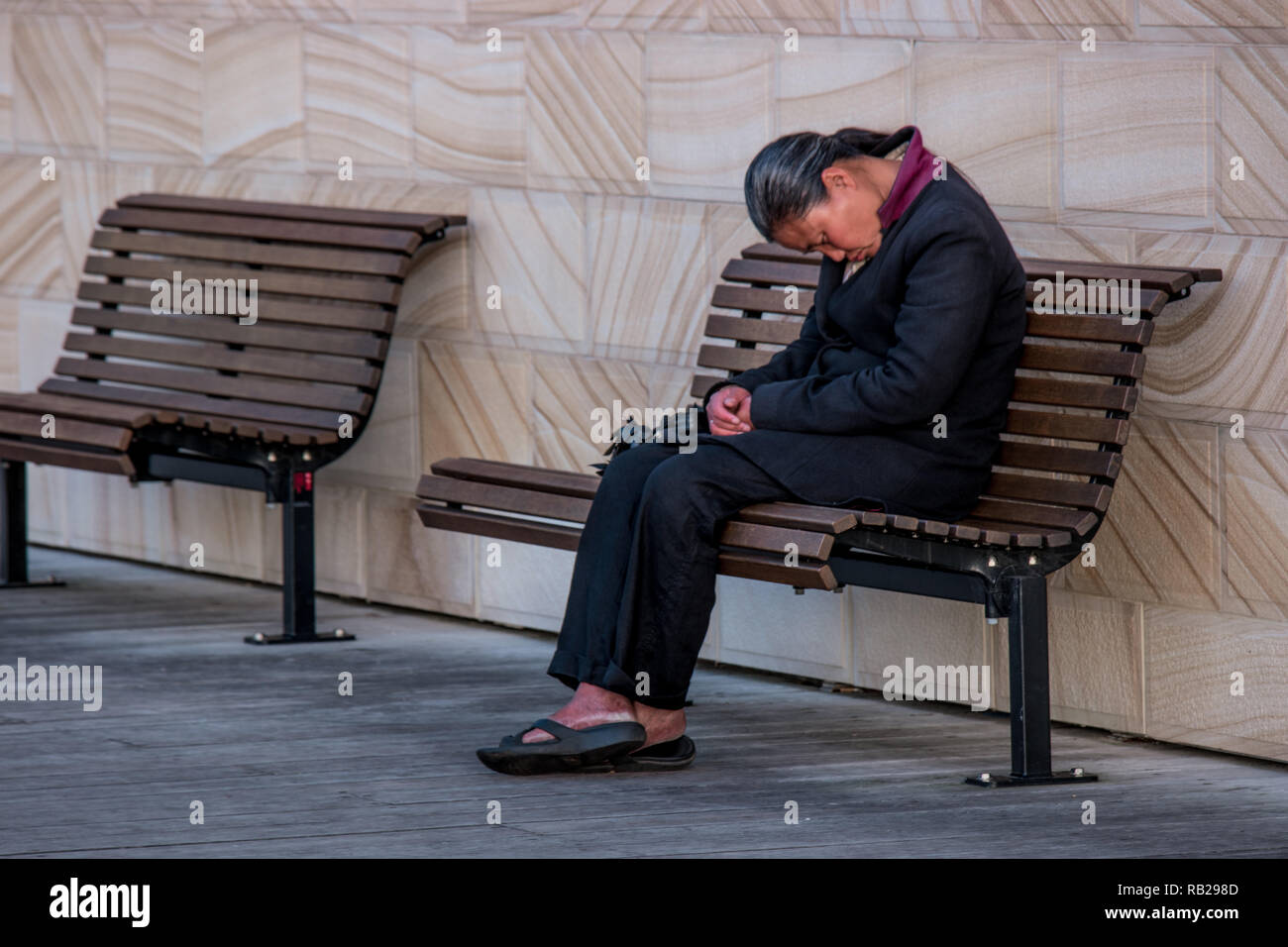 Femme de dormir sur un banc Banque D'Images