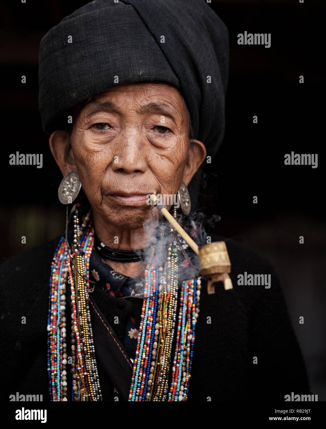 TONG KYAING, MYANMAR - CIRCA DÉCEMBRE 2017 : Portrait de femme de l'aîné Sai Wan Village Akha Kyaing Tong à fumer. Banque D'Images