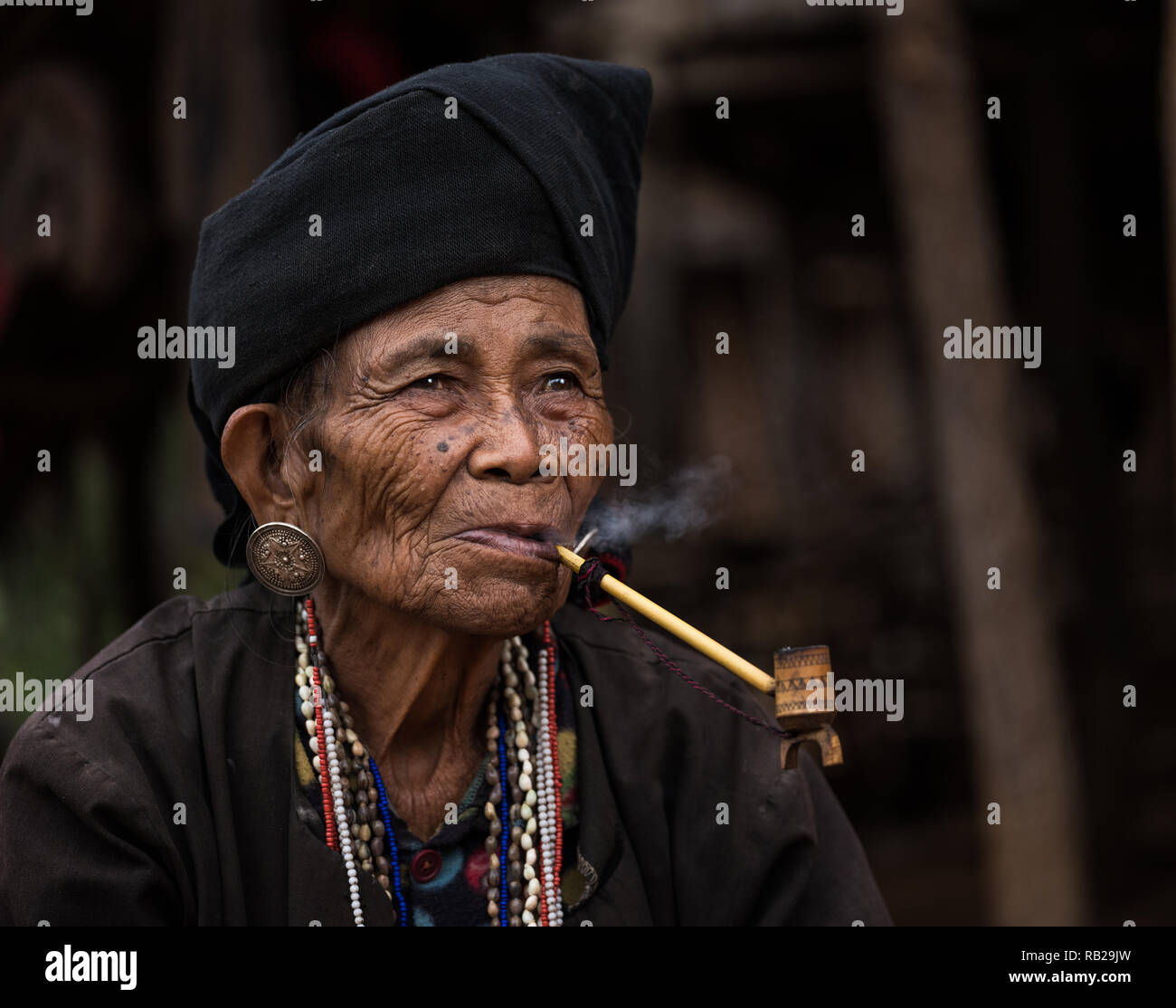 TONG KYAING, MYANMAR - CIRCA DÉCEMBRE 2017 : Portrait de femme de l'aîné Sai Wan Village Akha Kyaing Tong à fumer. Banque D'Images