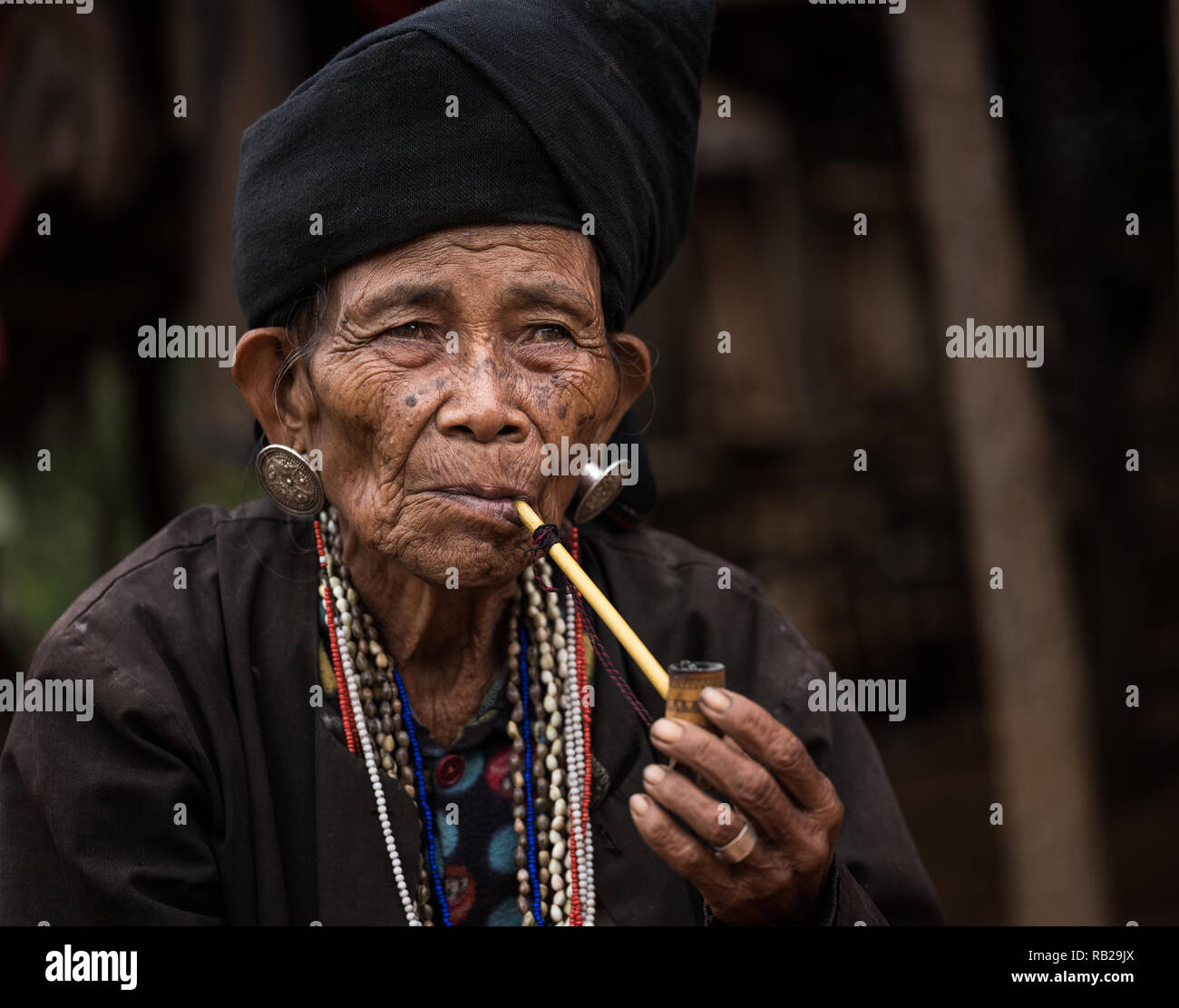TONG KYAING, MYANMAR - CIRCA DÉCEMBRE 2017 : Portrait de femme de l'aîné Sai Wan Village Akha Kyaing Tong à fumer. Banque D'Images