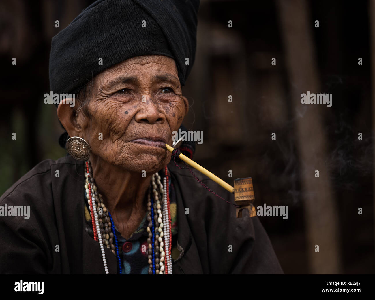 TONG KYAING, MYANMAR - CIRCA DÉCEMBRE 2017 : Portrait de femme de l'aîné Sai Wan Village Akha Kyaing Tong à fumer. Banque D'Images