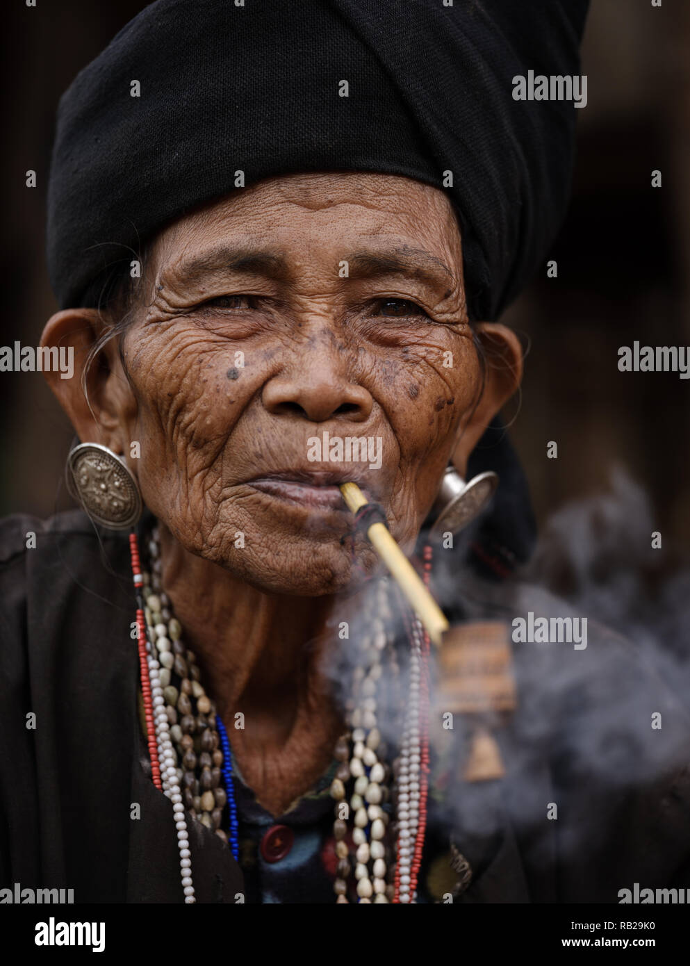 TONG KYAING, MYANMAR - CIRCA DÉCEMBRE 2017 : Portrait de femme de l'aîné Sai Wan Village Akha Kyaing Tong à fumer. Banque D'Images