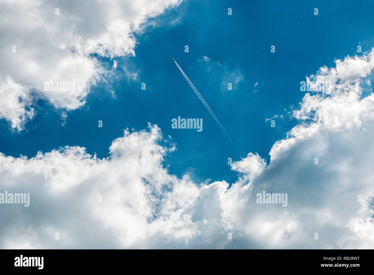 Un avion au-dessus des nuages dans le ciel bleu profond Banque D'Images