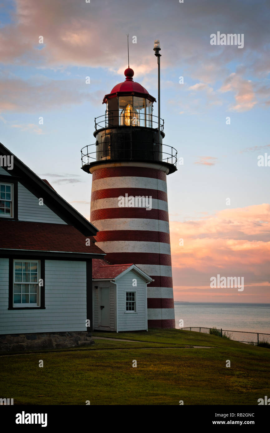 Lentille de Fresnel authentique de Quoddy head, de l'Ouest, célèbre pour son srtipes rouge et blanc, brille pendant le coucher du soleil dans le nord de la Nouvelle Angleterre. Il Banque D'Images