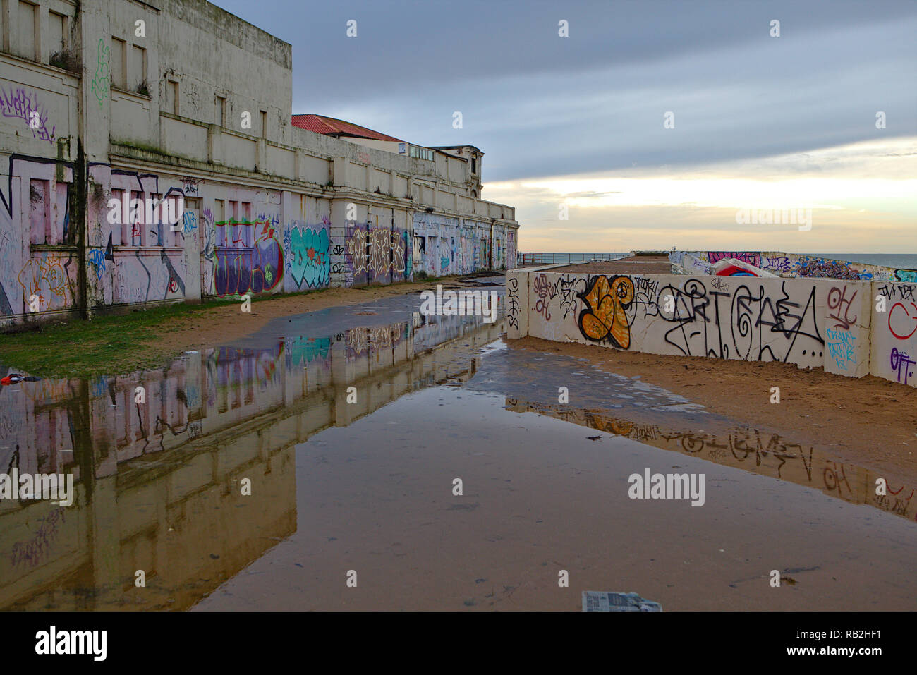 Des graffitis sur les murs en béton sur un jour de pluie par la mer à Margate Banque D'Images