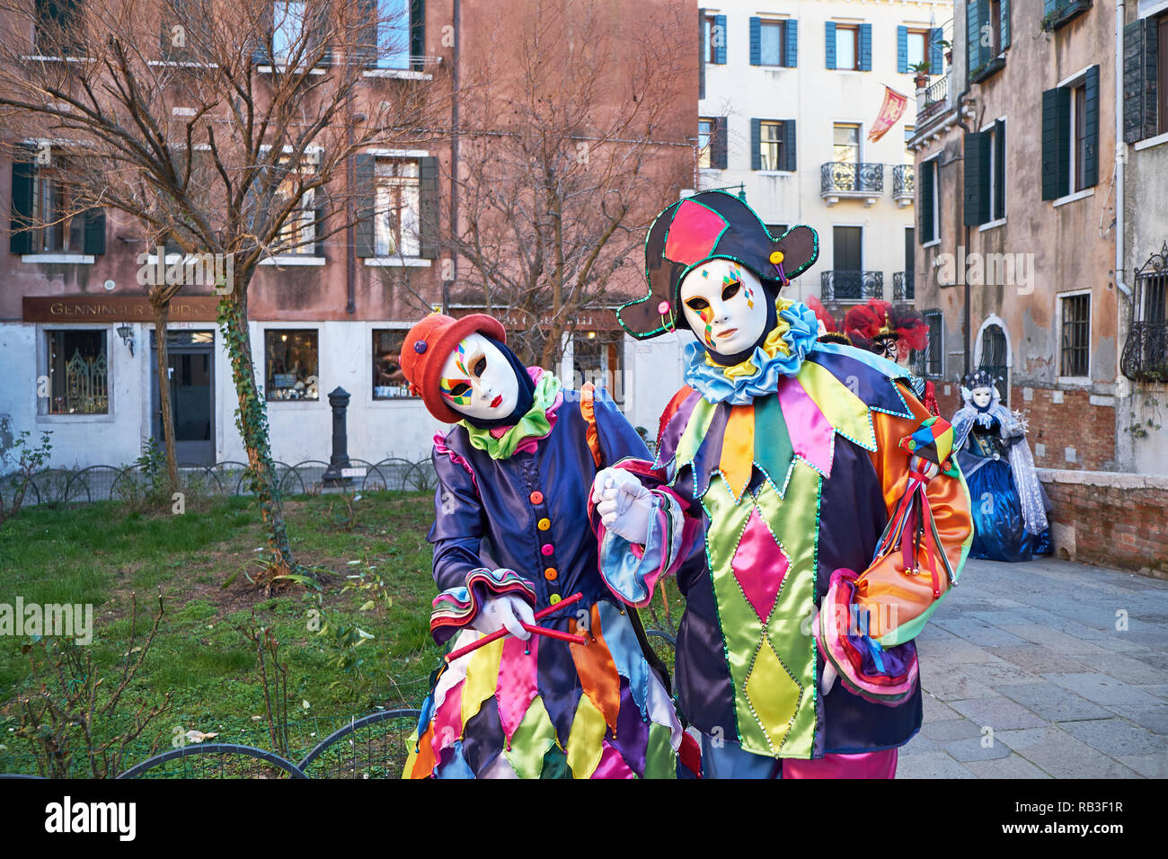Venise, Italie - Février 10, 2018 : Couple en masques blancs et costumes arlequin dans la rue pendant le carnaval Banque D'Images