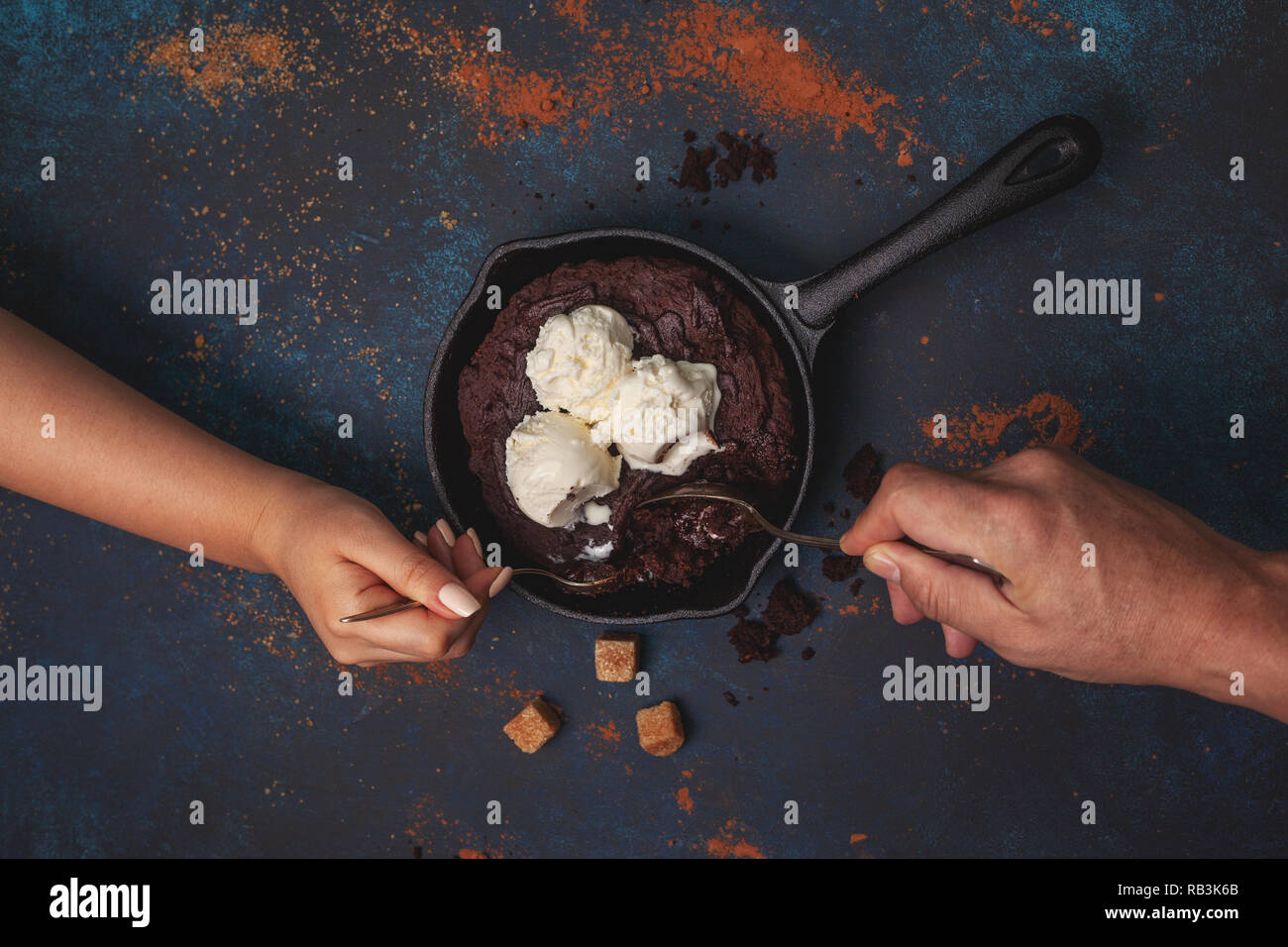 Brownie au chocolat avec crème et crème glacée à la vanille dans une casserole à fond bleu. Vue de dessus. Banque D'Images