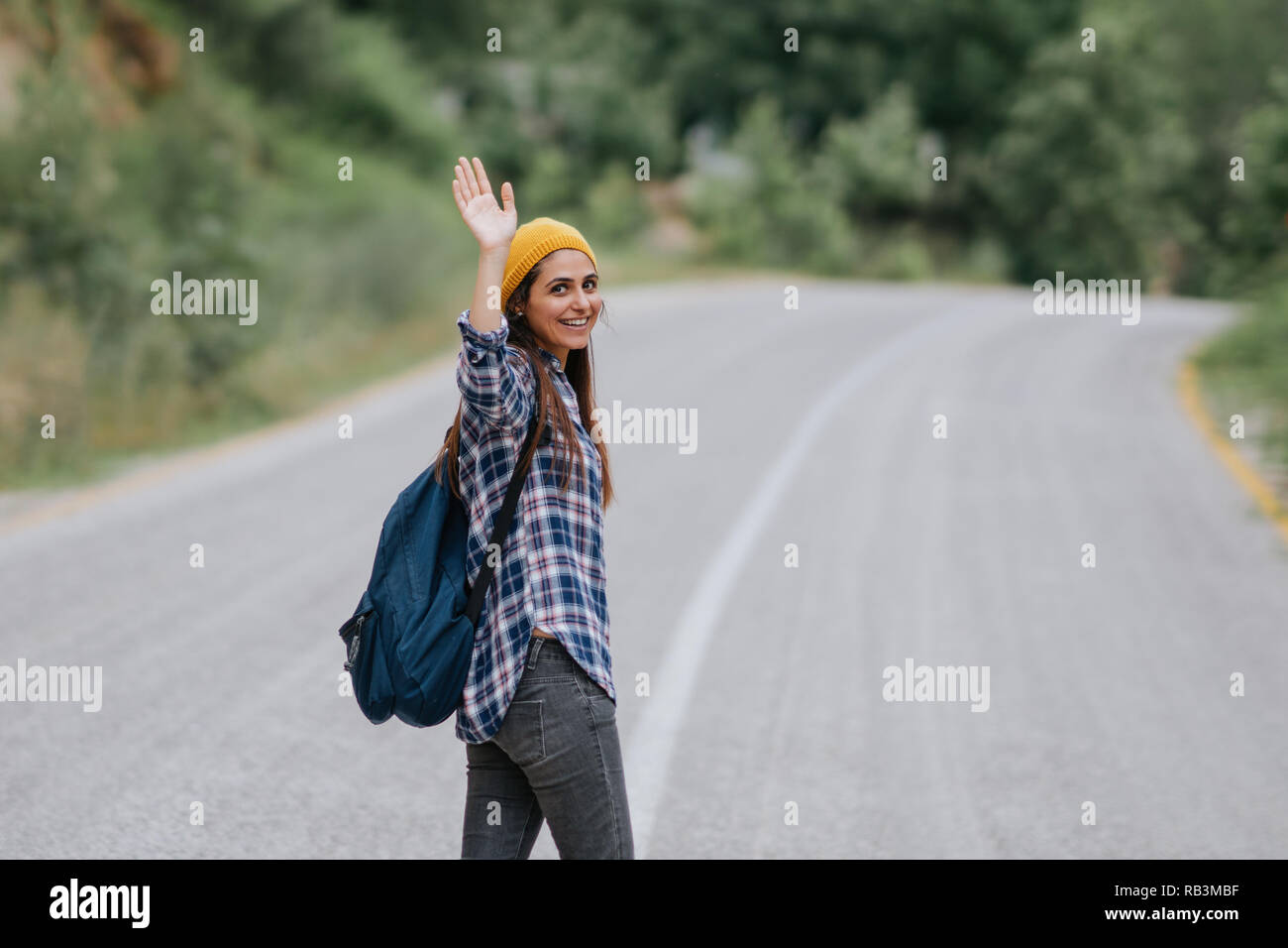 Traveler woman smiling and waving part sur la route des vacances, voyager Banque D'Images
