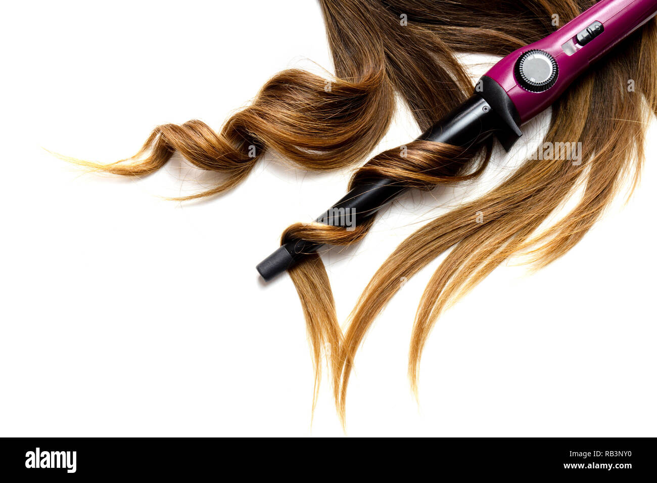 Long cheveux bouclés brun sur blanc fond isolé avec fer à friser Banque D'Images