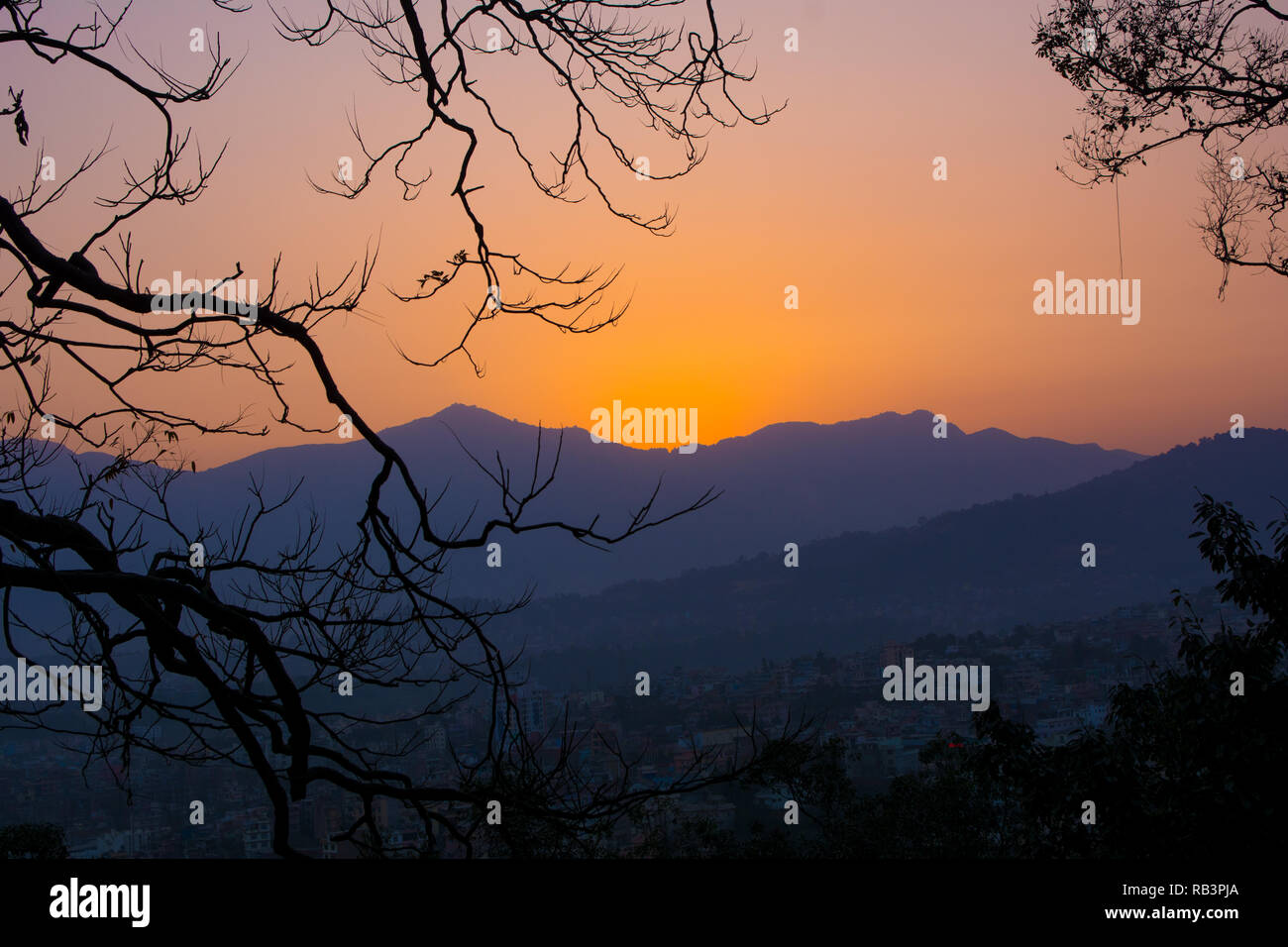 Vue d'un coucher du soleil dans un cadre d'arbres pour signifier un concept de tourisme Banque D'Images