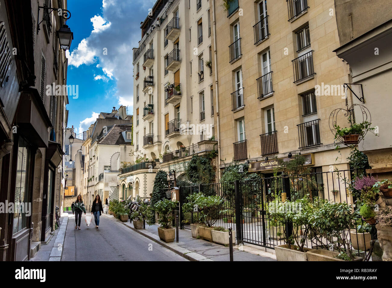 Deux filles marcher le long d'une rue tenant un sac shopping ensemble en face de Chantairelle un restaurant Français Rue Laplace ,Paris ,France Banque D'Images