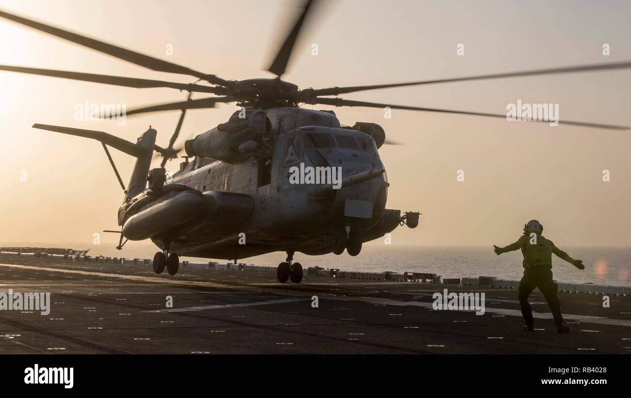 La mer d'OMAN - l'aviation de la Marine américaine Boatsmate 3e classe Handler Jake Bonet, affecté du groupe amphibie d'Essex (ARG), guides un U.S. Marine Corps CH-53E Super Stallion avec Marine à rotors basculants moyen 166 Escadron renforcé, 13e Marine Expeditionary Unit (MEU), à bord de la classe Wasp-navire d'assaut amphibie USS Essex (DG 2), 5 janvier 2019. L'Essex est le navire amiral de la Essex ARG et, avec l'entrepris 13e MEU, est déployé sur le 5e flotte américaine zone d'opérations à l'appui des opérations navales pour assurer la stabilité maritimes dans la région Centrale, reliant la Méditerranée et la CIP Banque D'Images