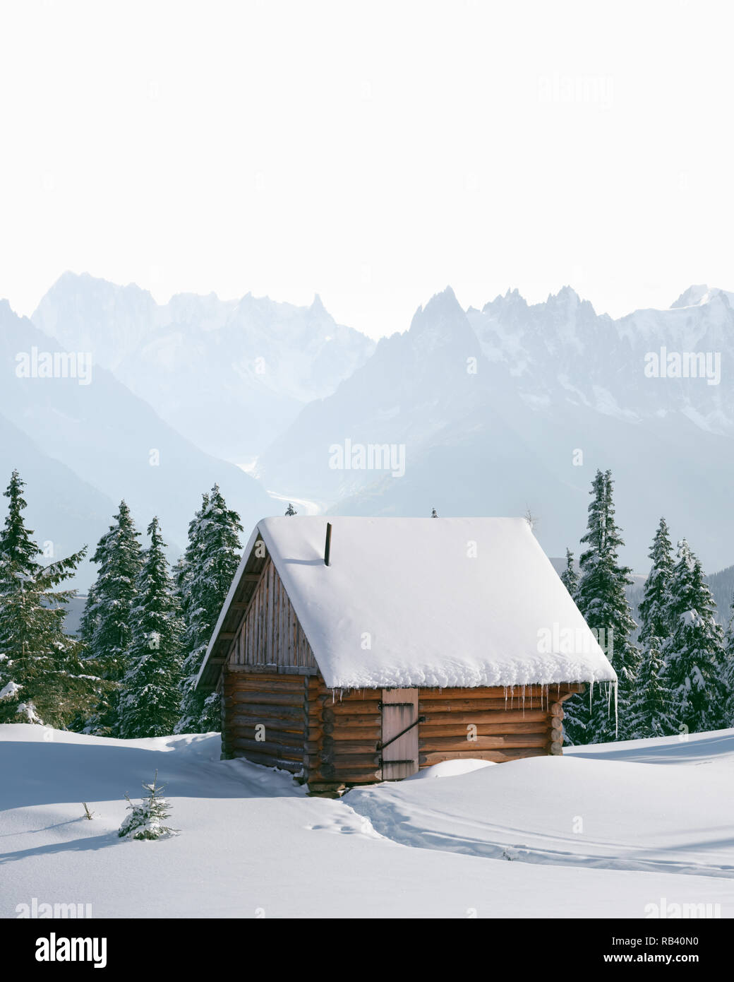 Paysage d'hiver fantastique avec maison en bois dans les montagnes enneigées. Concept de vacances de Noël Banque D'Images