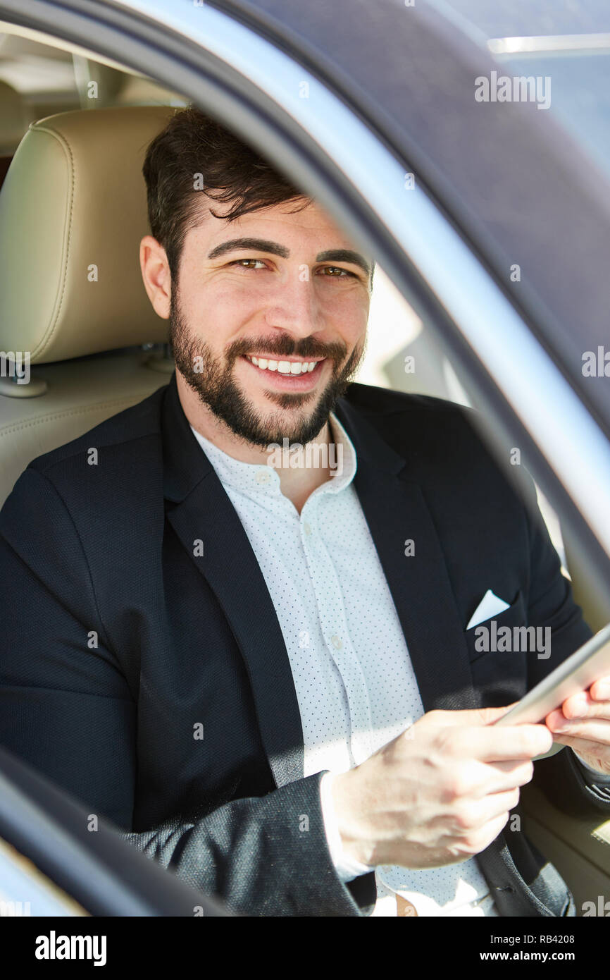 L'homme d'affaires réussie dans l'auto en voyage d'affaires avec ordinateur tablette Banque D'Images