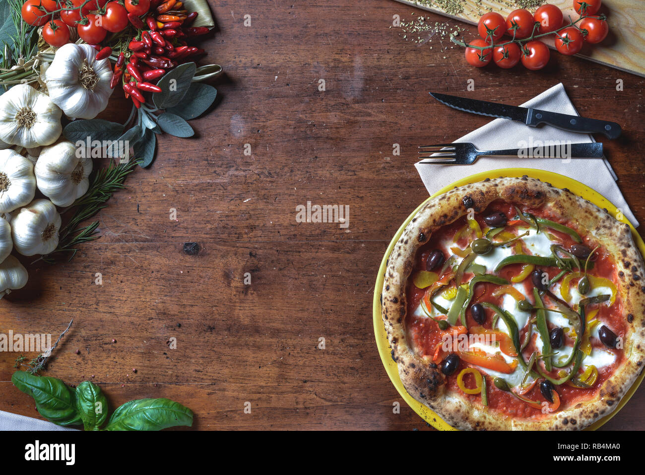 Vue de dessus le fond de la pizza napolitaine italien avec des poivrons, olives, tomates et fromage. composition du châssis avec des ingrédients d'espace libre pour le texte Banque D'Images