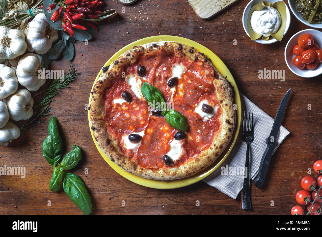 Vue de dessus le fond italien pizza napolitaine avec pepperoni, salami, fromage, olives noires et basilic sur composition du châssis Banque D'Images