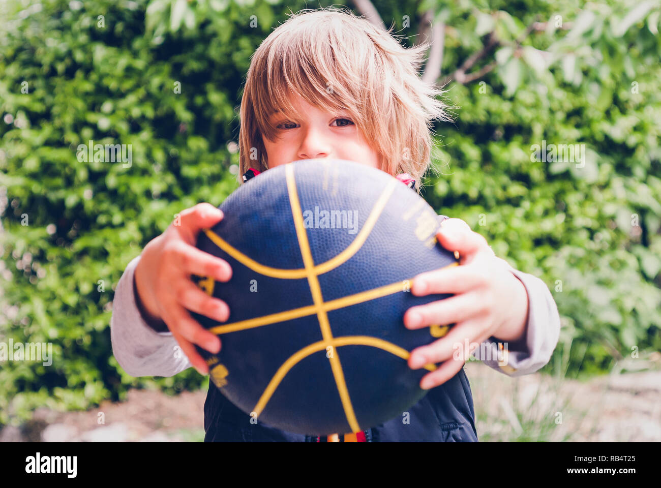 Petit enfant basket-ball en plein air - connexions sensorielles Banque D'Images