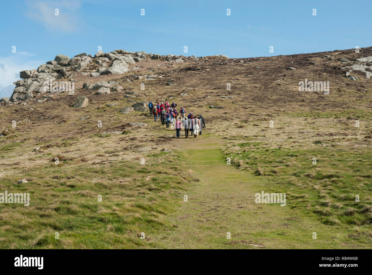 Un groupe de marcheurs dans la distance sur la tête en bas, Bryher Shipman, Îles Scilly, par un beau jour de printemps ensoleillé. Banque D'Images