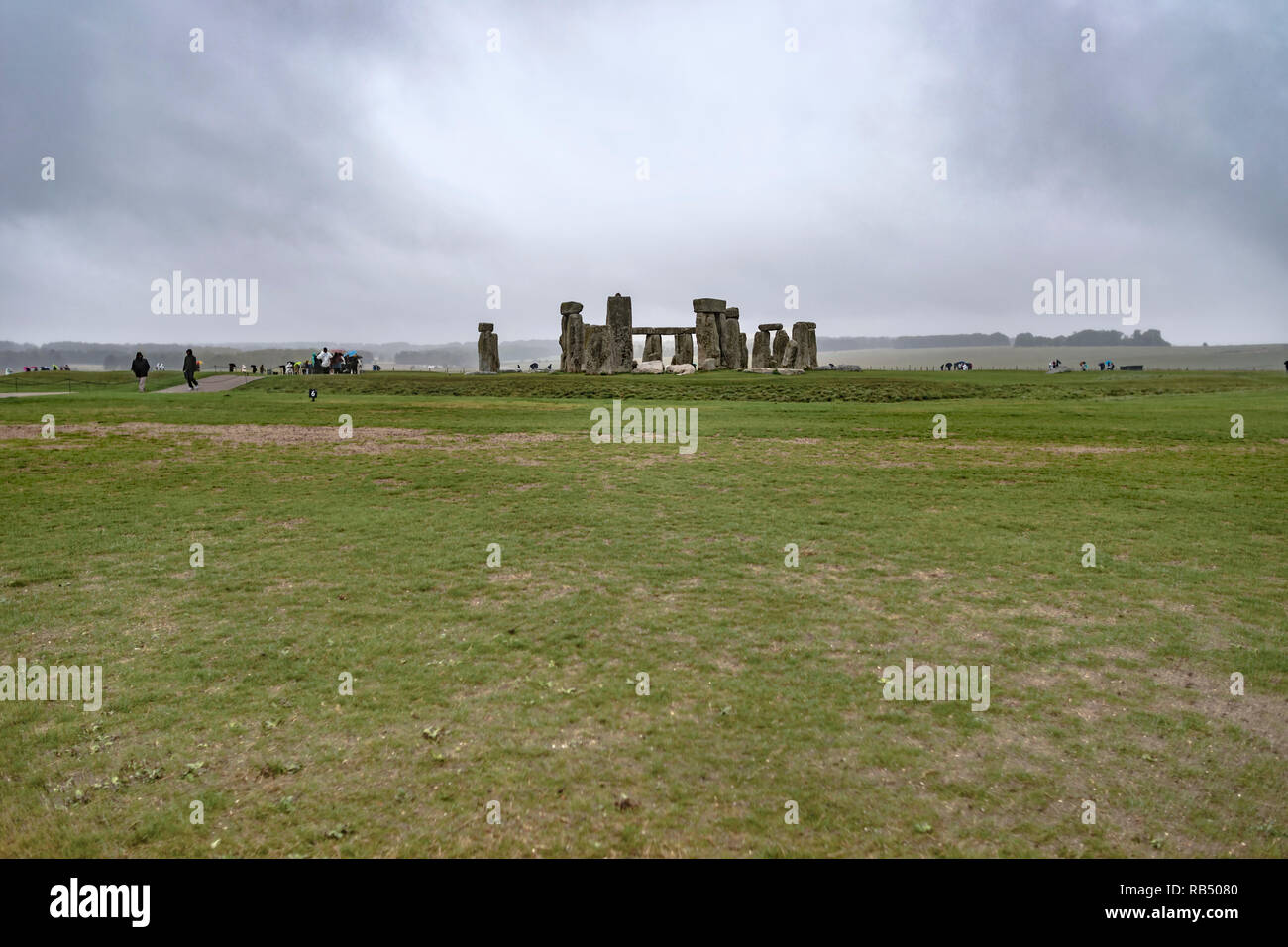 Wiltshire, Angleterre - le 22 septembre 2018 : sur un mauvais temps rainy day stand les pierres de Stonehenge au milieu de l'herbe entourée par les touristes. Banque D'Images