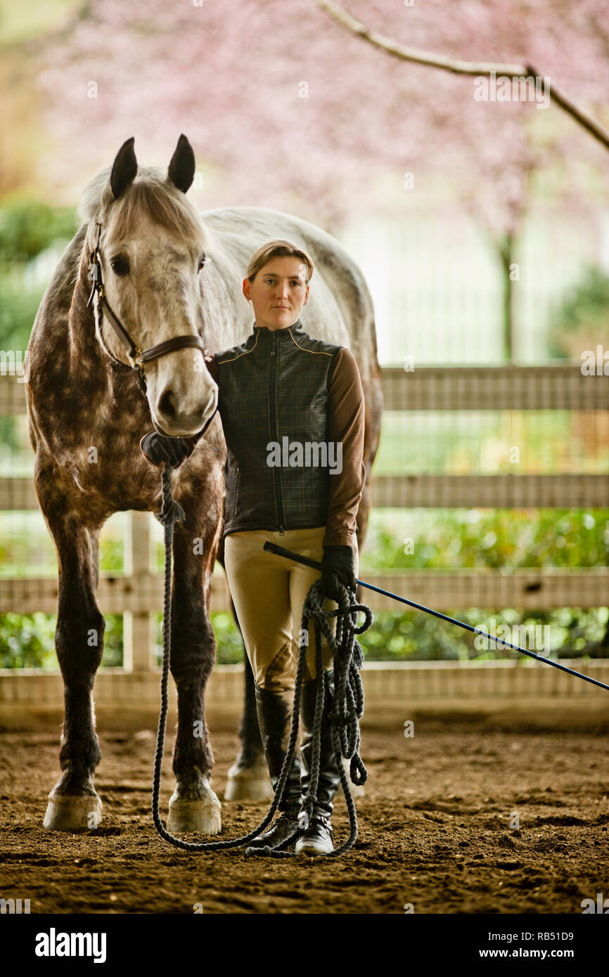 Portrait of a Mid adult woman et son cheval dans une étable. Banque D'Images