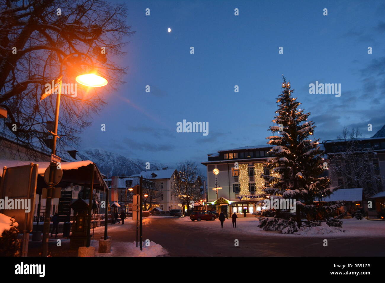 Bad Goisern, Hallstatt. Vue du centre, l'arbre de Noël et les montagnes couvertes de neige dans la nuit. Banque D'Images