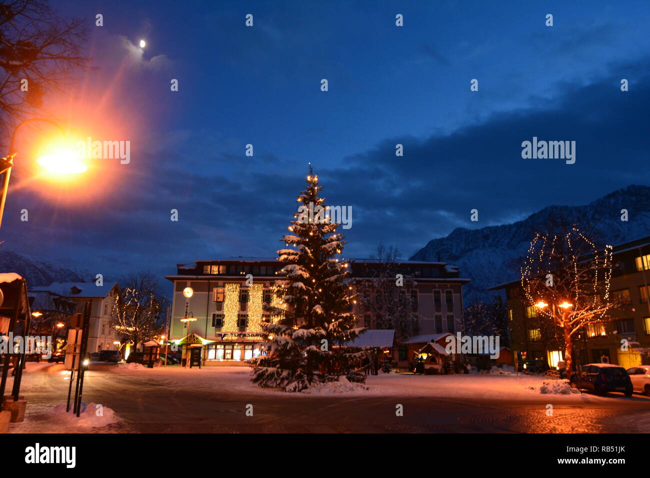 Bad Goisern, Hallstatt. Vue du centre, l'arbre de Noël et les montagnes couvertes de neige dans la nuit. Banque D'Images