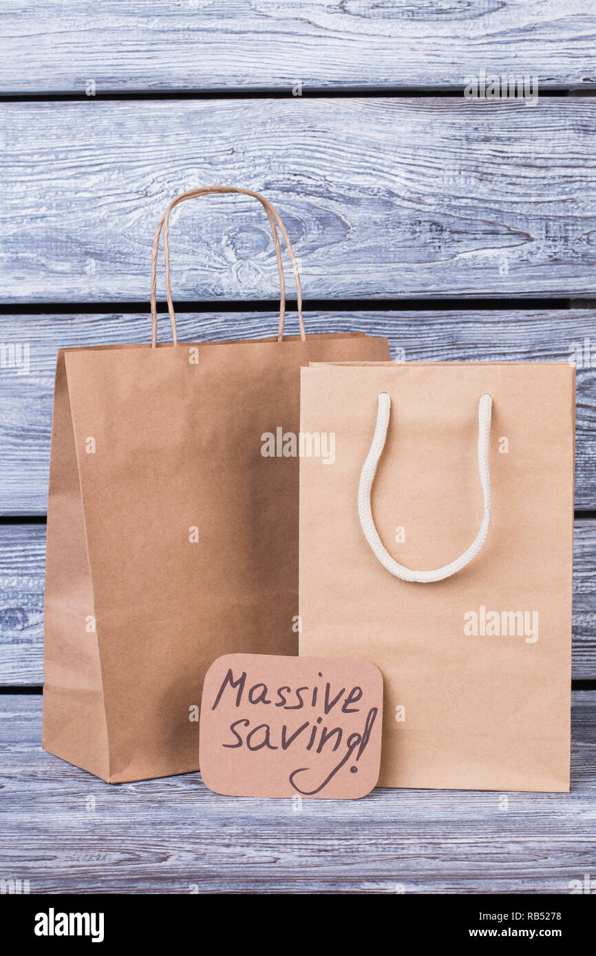 Recycler les sacs en papier sur fond de bois. Des sacs en papier brun avec  l'inscription de la carte et l'épargne massive. Les entreprises, le  commerce et le marketing Photo Stock -