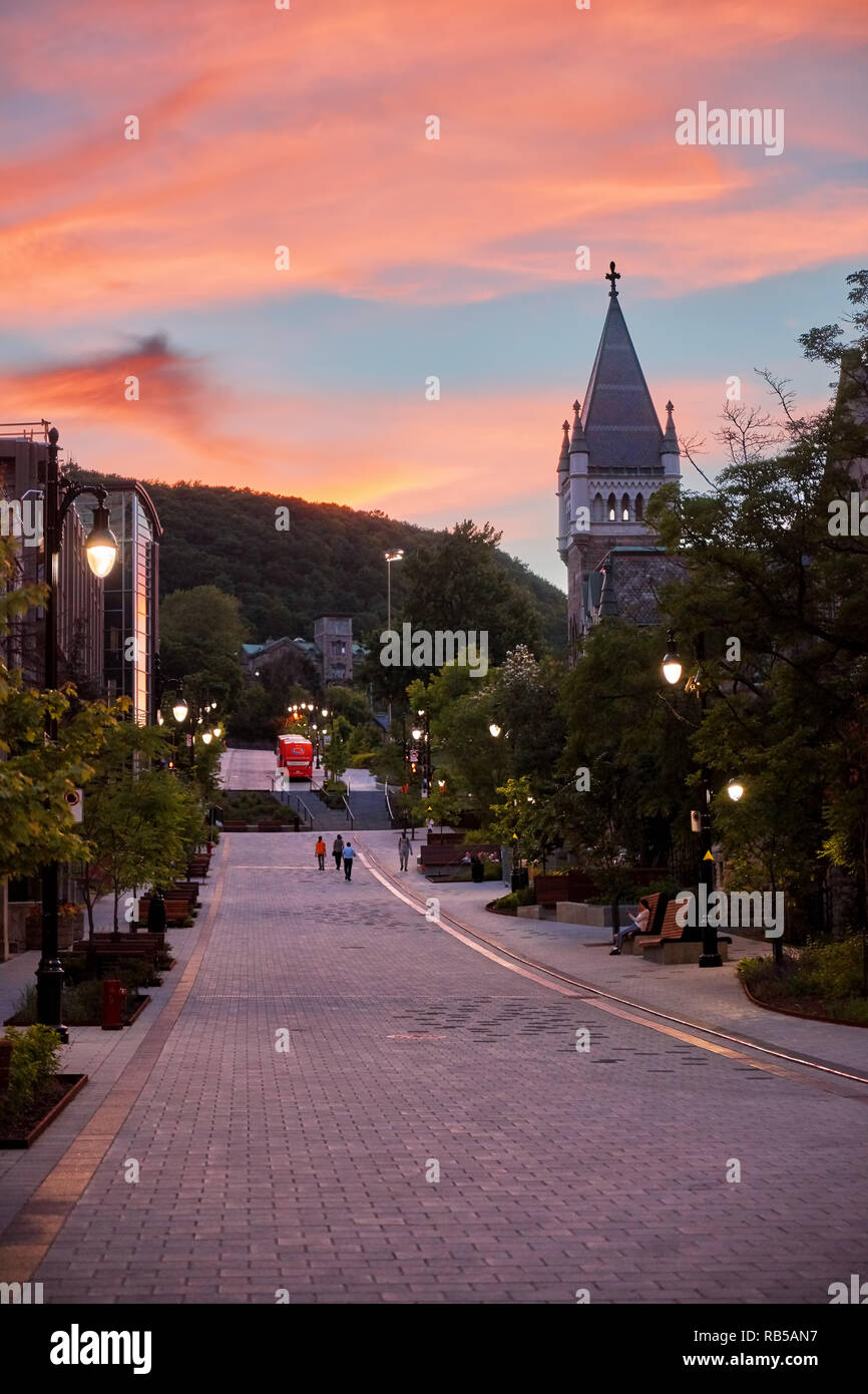 Moody coucher du soleil à scène, rue Mctavish. Les gens qui marchent dans la rue et la tour de l'Université Mcgill morrice hall à Montréal, Canada. Banque D'Images