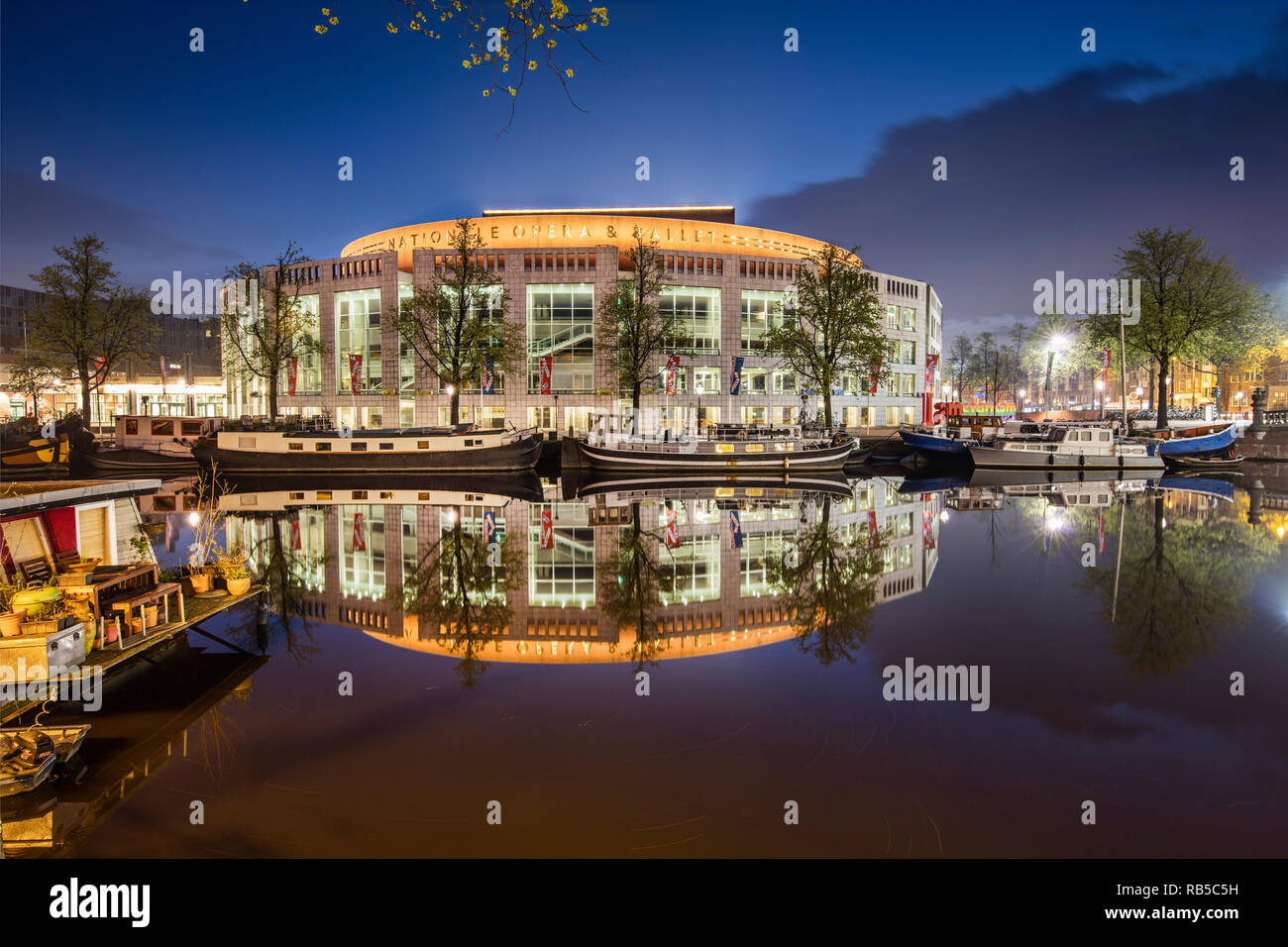 Les Pays-Bas, Amsterdam, le Stopera, le Dutch National Opera and Ballet Theatre le long de la rivière Amstel. À l'aube. Banque D'Images