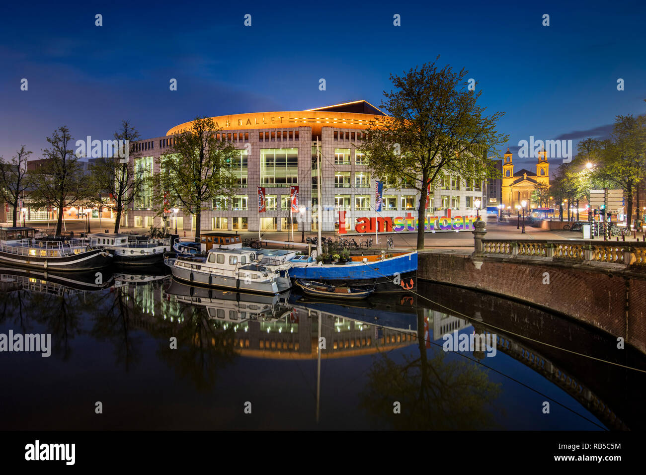 Les Pays-Bas, Amsterdam, le Stopera, le Dutch National Opera and Ballet Theatre le long de la rivière Amstel. À l'aube. Banque D'Images