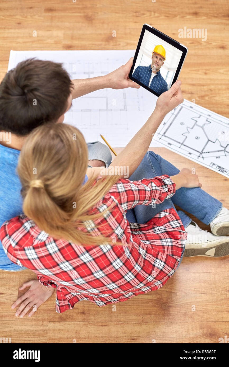 Couple having appel vidéo avec builder Banque D'Images