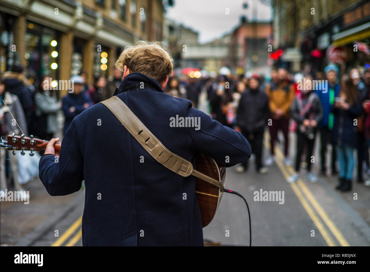 Musicien ambulant Brick Lane Market - un musicien de rue divertit les foules au le marché du dimanche sur la célèbre London Brick Lane. Banque D'Images