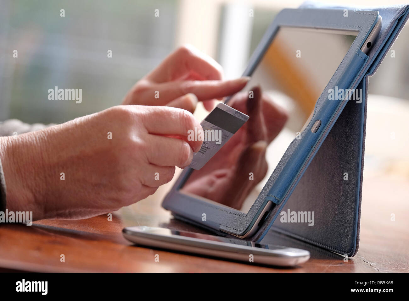 Senior female en utilisant une carte de crédit pour un paiement en ligne Banque D'Images Senior female en utilisant une carte de crédit pour un paiement en ligne Banque D'Images