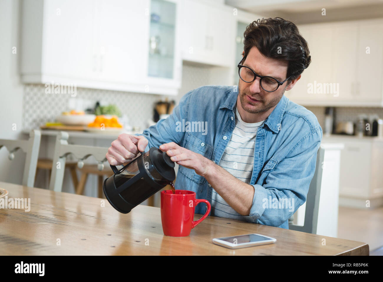Man pouring coffee à partir de la presse française dans la tasse Banque D'Images