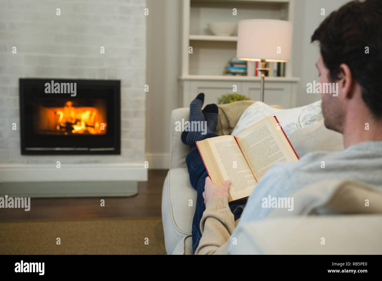 Man reading a book in living room Banque D'Images