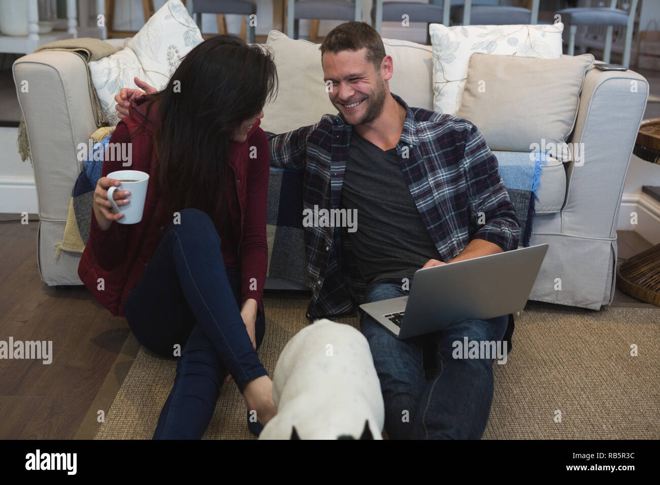 Couple avec leur chien de compagnie dans la salle de séjour Banque D'Images