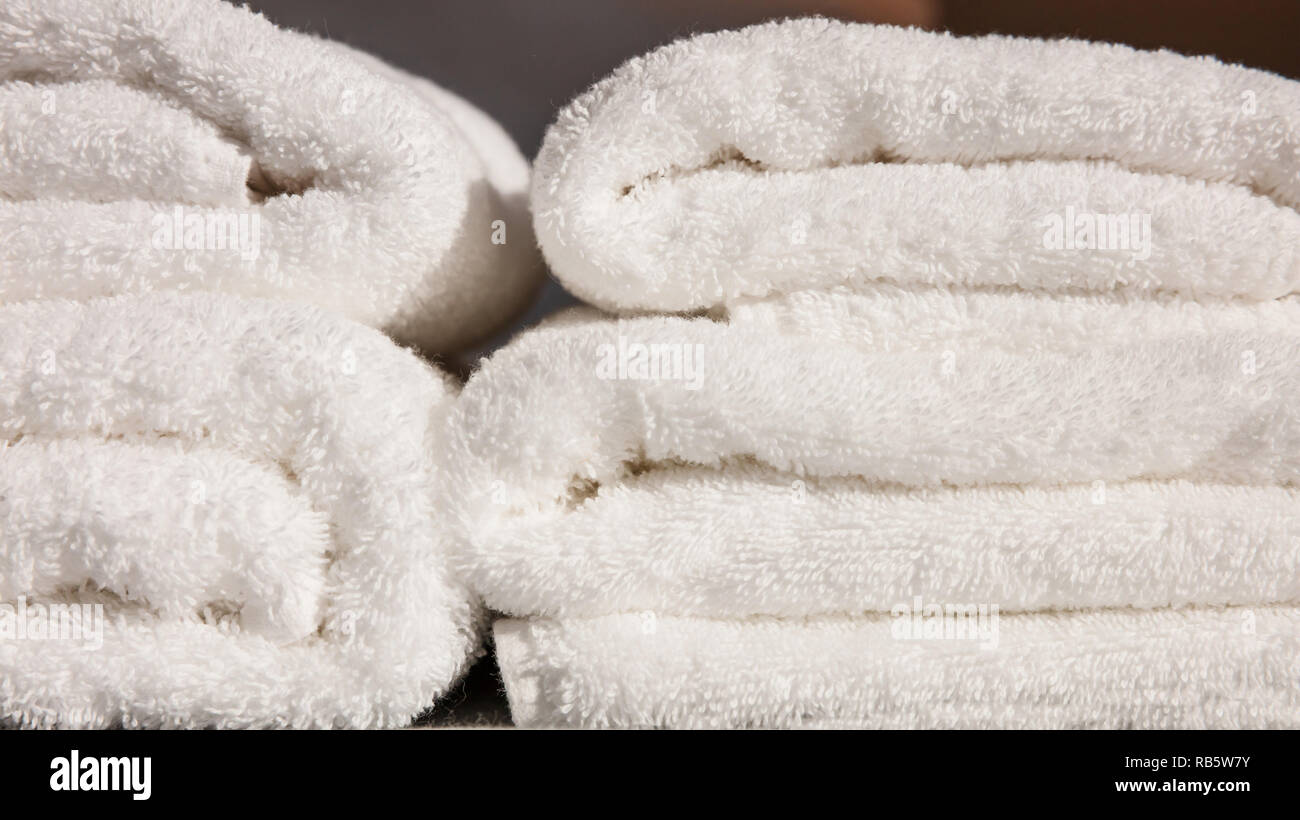 Les serviettes de bain. Pile de serviettes pliées blanc arrière-plan. Vue rapprochée avec des détails Banque D'Images