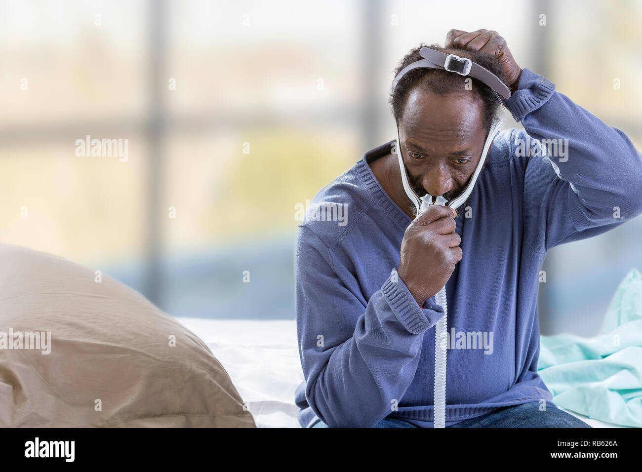 L'homme à l'aide d'un appareil de PPC (pression positive continue) mask pour traiter l'apnée du sommeil. Banque D'Images