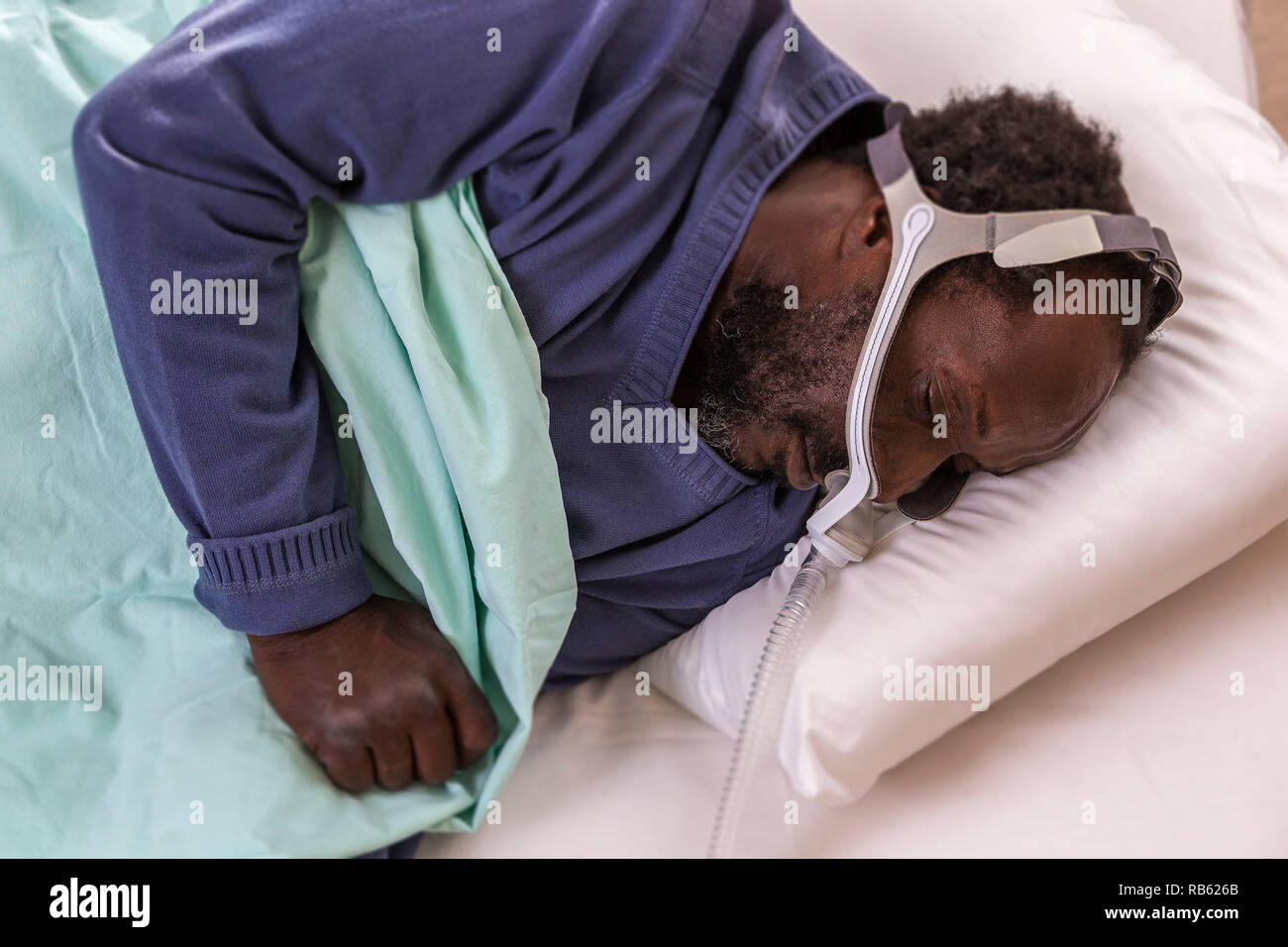 L'homme à l'aide d'un appareil de PPC (pression positive continue) mask pour traiter l'apnée du sommeil. Banque D'Images