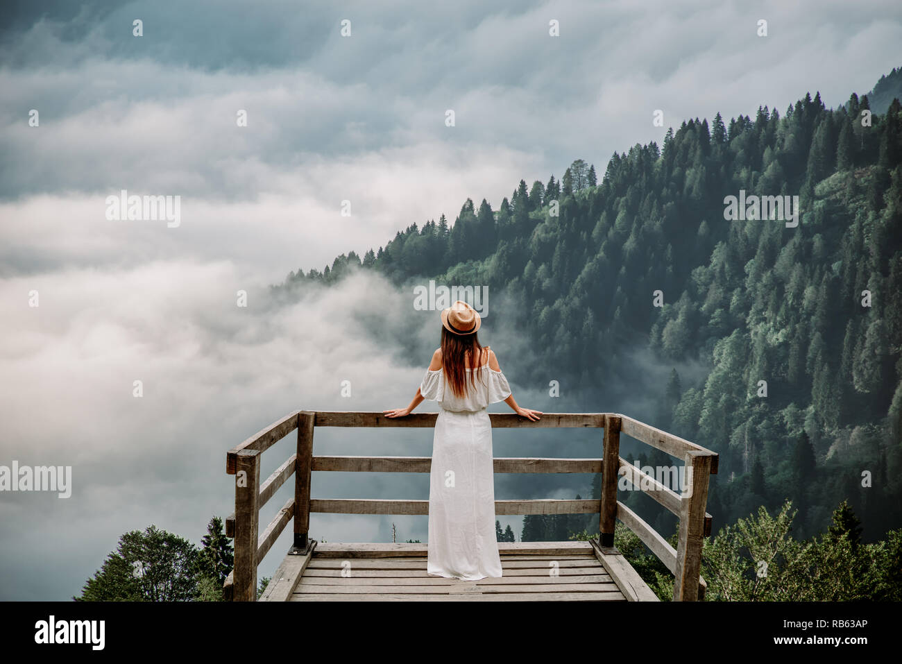 La femme avec chapeau et robe blanche debout contre nature dans les montagnes Banque D'Images