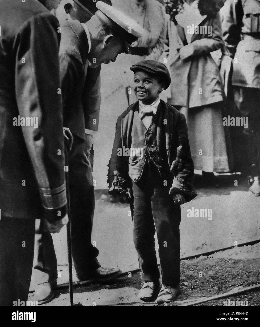 Photographie du roi George V (1865 - 1936), Roi du Royaume-Uni et les Dominions britanniques et empereur des Indes. Le roi George se réunit avec un enfant travailleur au cours de sa visite à Sunderland. Datée 1918 Banque D'Images