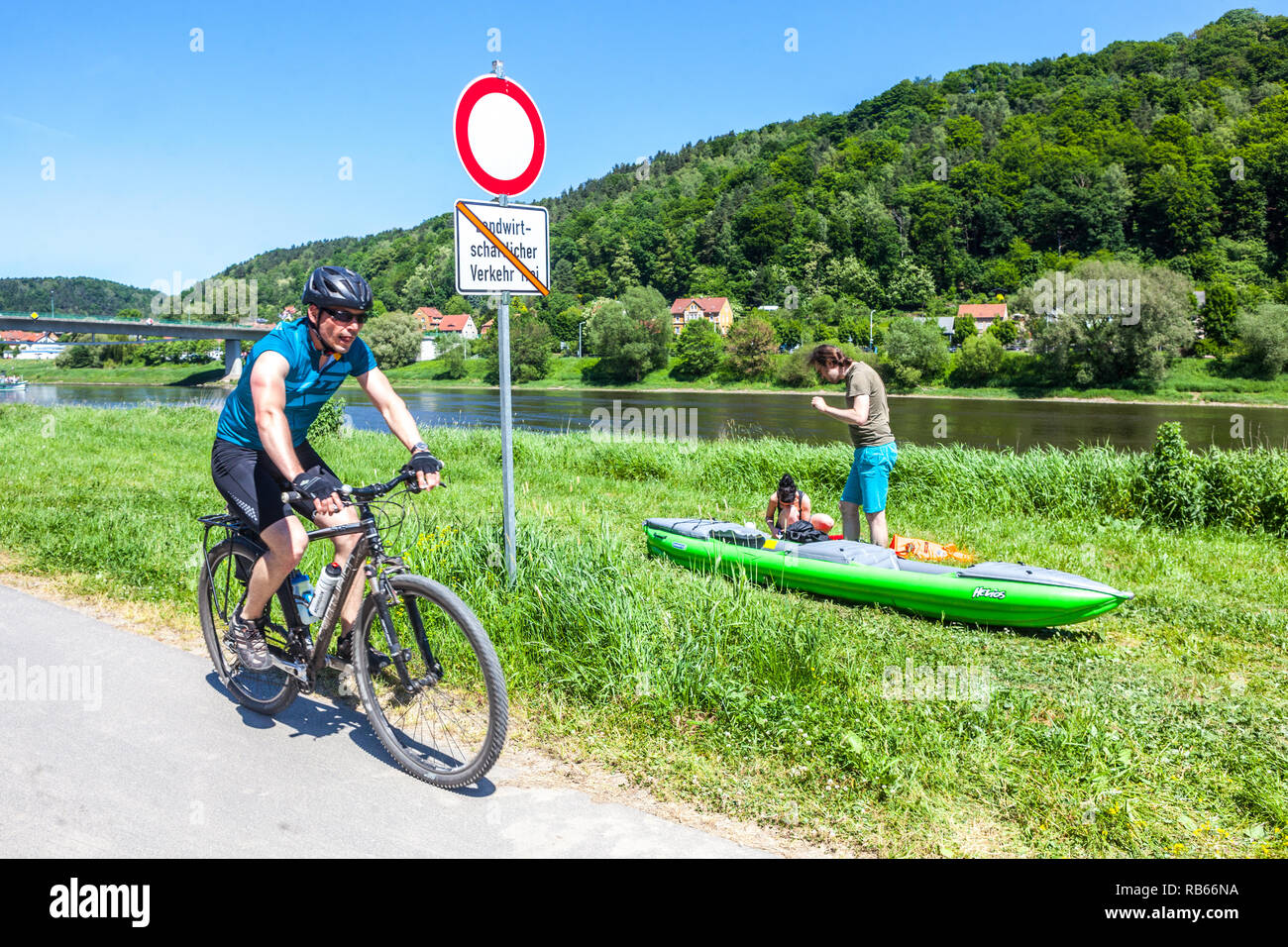 Les personnes actives, biker et canoéiste sur berge de la rivière La vallée de l'Elbe près de Bad Schandau, Saxe Allemagne Banque D'Images