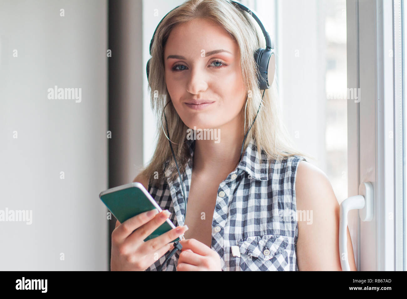 Beautiful Girl smiling et écoute la musique avec à la maison Banque D'Images