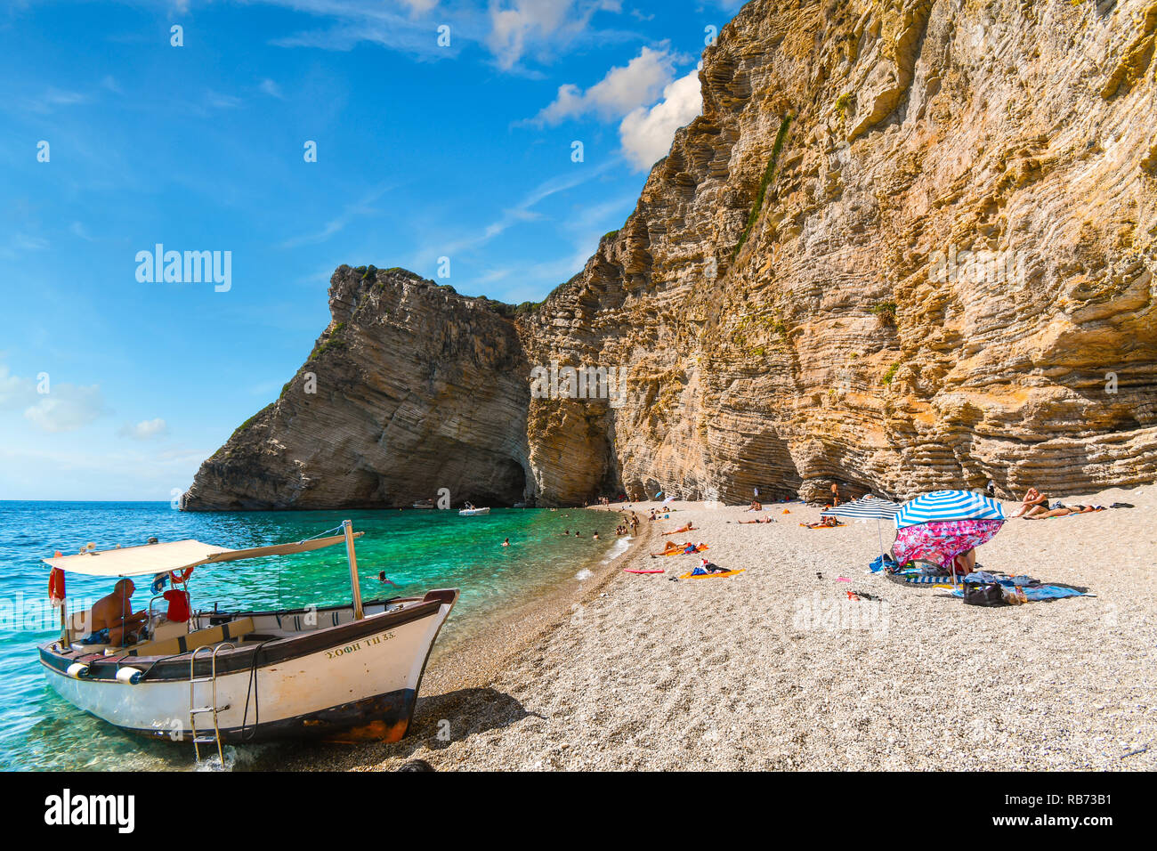 Un bateau attend sur la plage de sable de transport de touristes retour à la ville à partir de la Paradise Beach, également connu sous le nom de Chomi Beach, sur l'île de Corfou en Grèce Banque D'Images