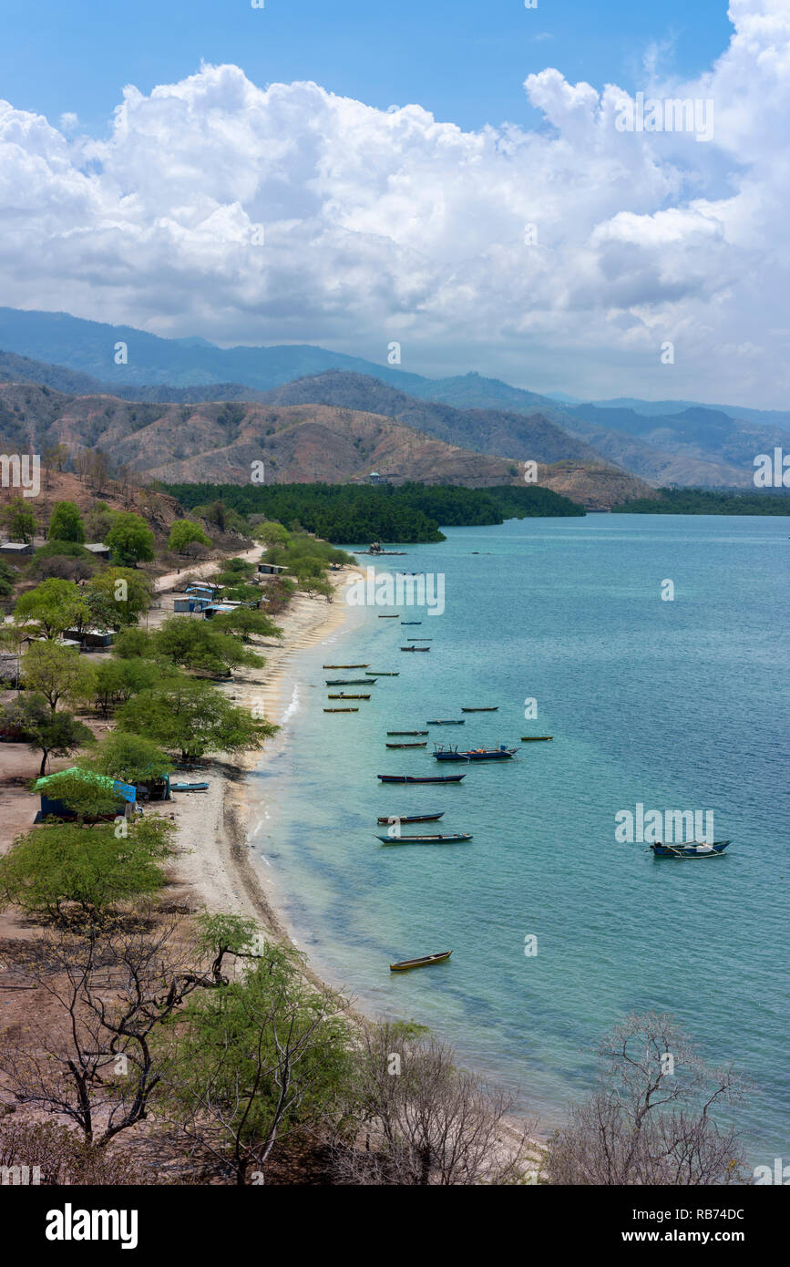 Les bateaux de pêche et un petit village sur la côte nord de Timor Leste à la fin de la saison sèche. Banque D'Images