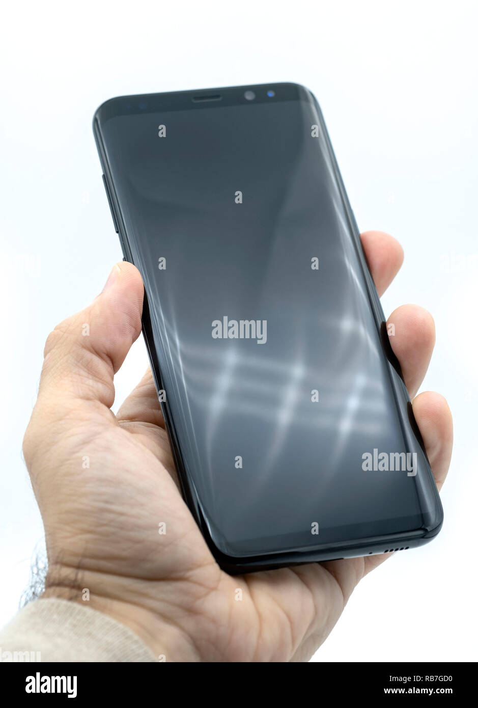 Main tenant le Samsung Galaxy S8 Plus smart phone découper sur un fond blanc Banque D'Images