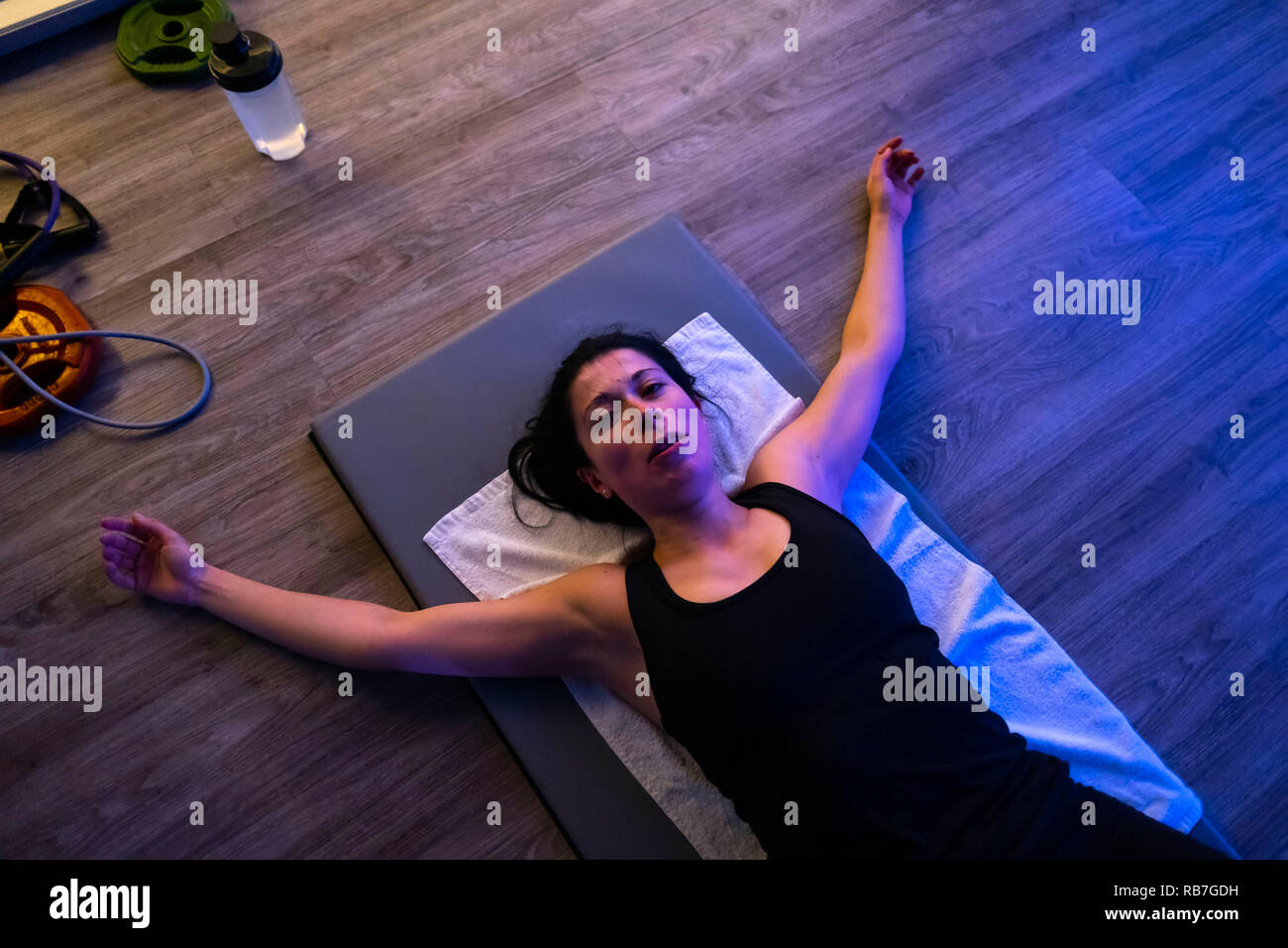 Vue aérienne d'un épuisé athlète féminin allongé sur un tapis dans la salle de sport Banque D'Images