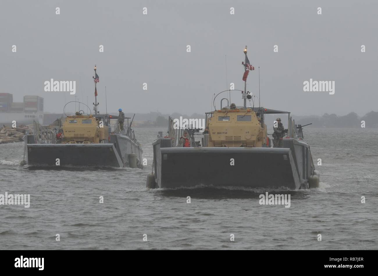 Les soldats de l'Armée américaine affecté à la 3e Bataillon, 27e Régiment d'artillerie et 188ème Bataillon de soutien de la Brigade mixte exécuter-logistique-sur-la-Rive (JLOTS) formation avec les marins de l'Armée de la 7e Brigade de transport au large de la baie de Chesapeake, en Virginie de l'Île à Craney lors de l'opération Neptune Fury, le 6 décembre 2016. Un système de roquettes d'artillerie à grande mobilité (HIMARS) élément ont voyagé sur des engins de débarquement mécanisées (LCM) à la rive puis exécuté des missions de tir simulé HIMARS. Banque D'Images